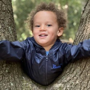 child poking through the tree