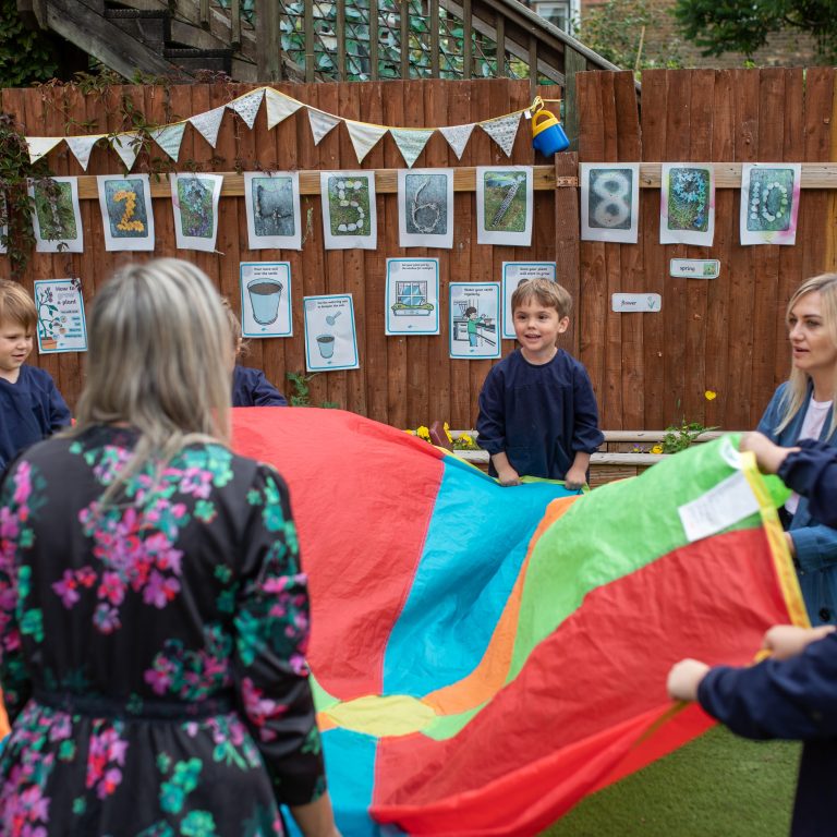 students and teachers using a parachute