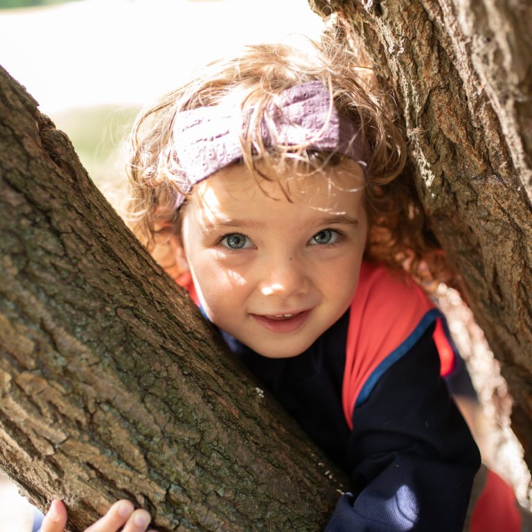 girl stood in between trees