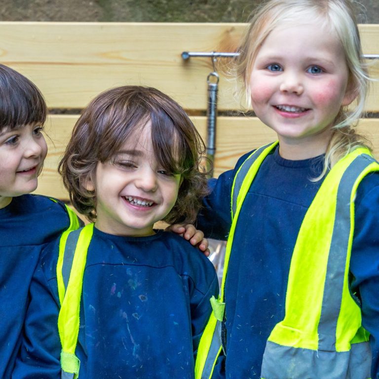 3 children holding their arms around each other