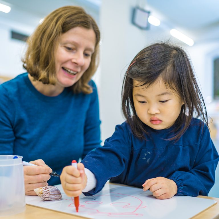 Little girl working with her teacher