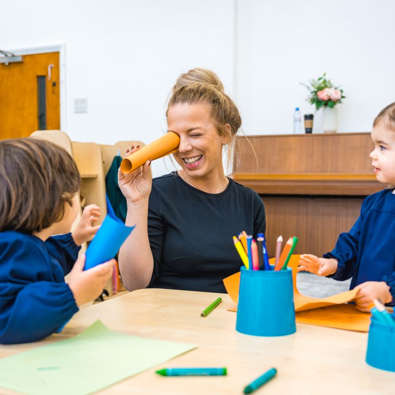 young students doing crafts with their teacher