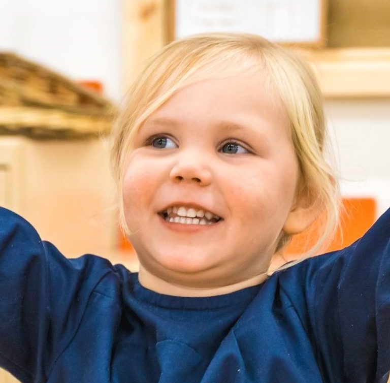 a child with her arms in the air