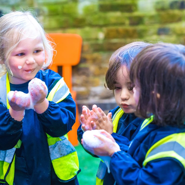 Little children playing with bubbles